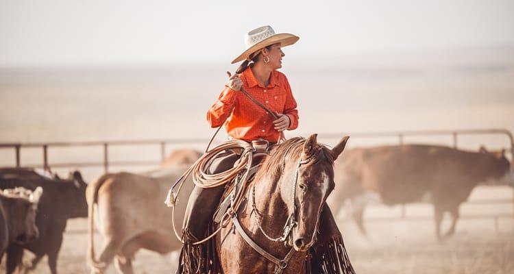 Image of woman on horse with lasso.